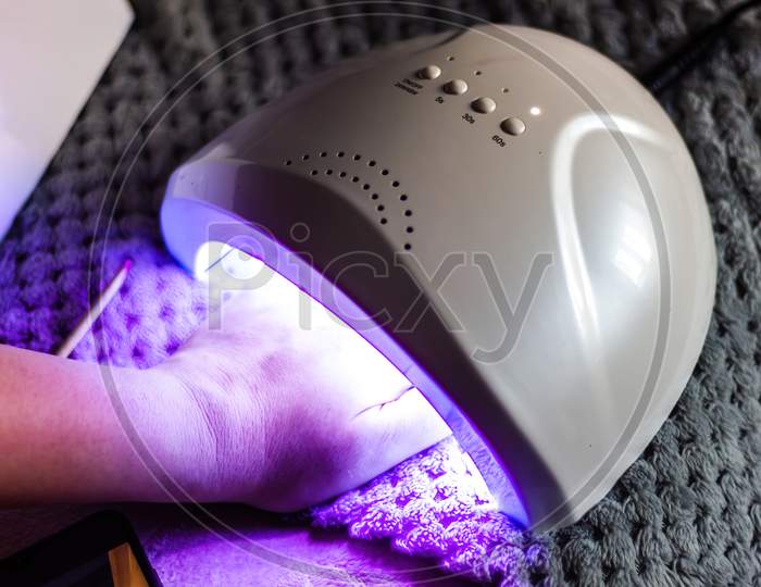 Caucasian Female Does Self Nail Polish Drying By Using Uv Led Technique