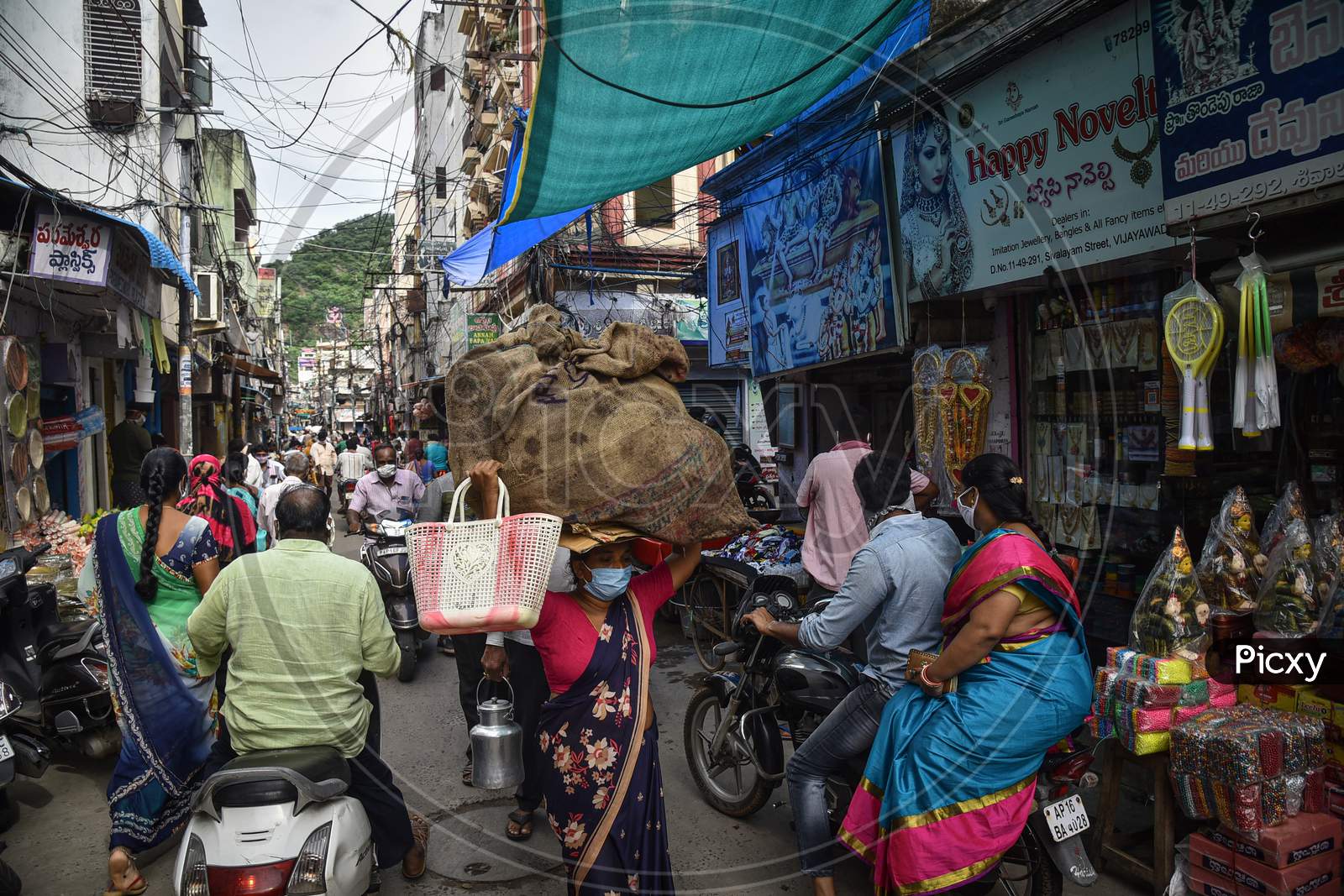 A Woman Carries Essentials In A Gunny Sack Over Her Head At One Town, In Vijayawada, August 03, 2020.