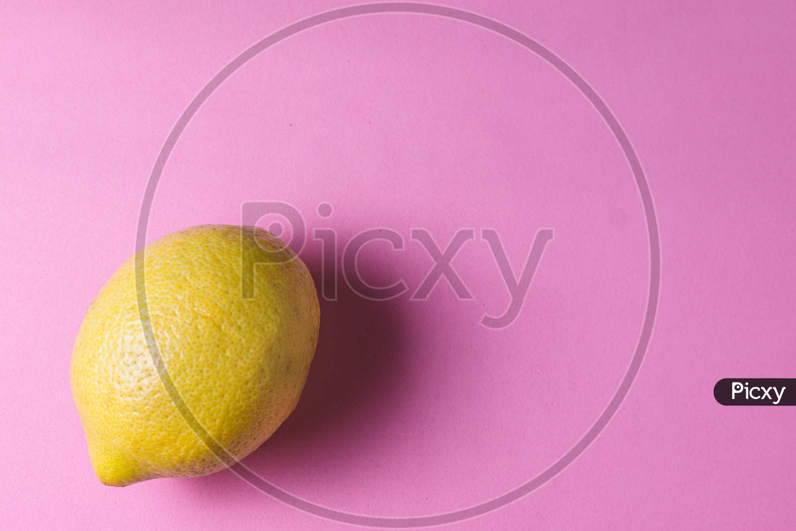 A yellow lemon on a rose background