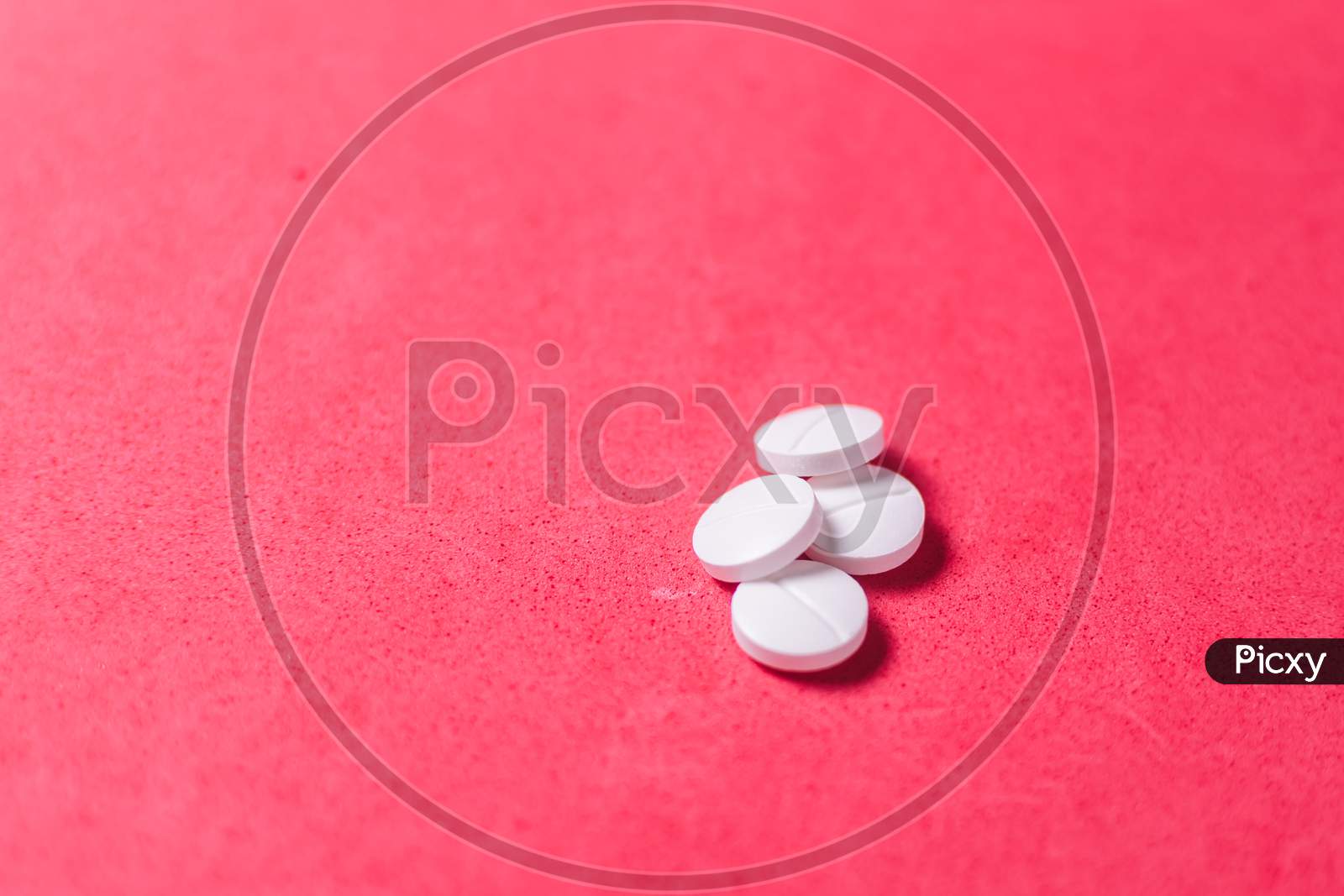 White pills in a red background