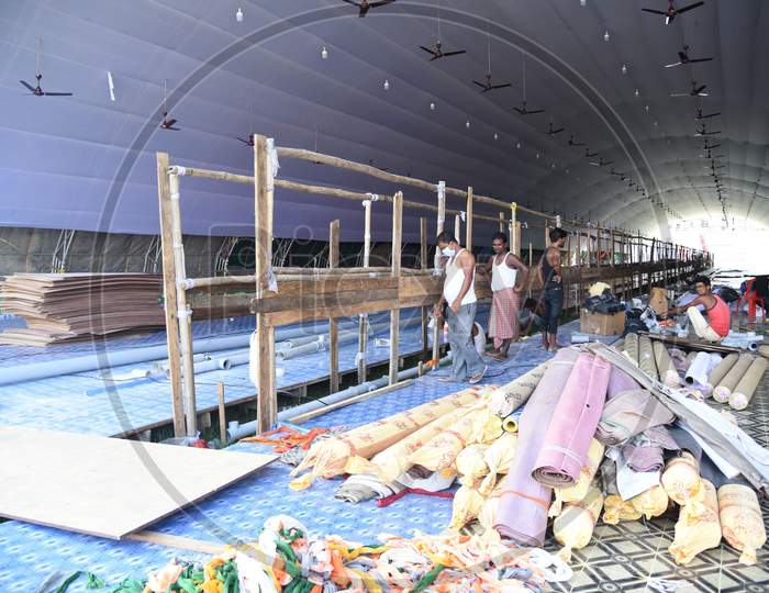 Workers carry materials for the construction of a COVID care centre for the treatment of COVID-19 infected patients, at Nehru Stadium in Guwahati on August 3, 2020.