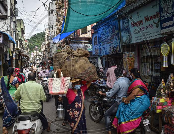 A Woman Carries Essentials In A Gunny Sack Over Her Head At One Town, In Vijayawada, August 03, 2020.