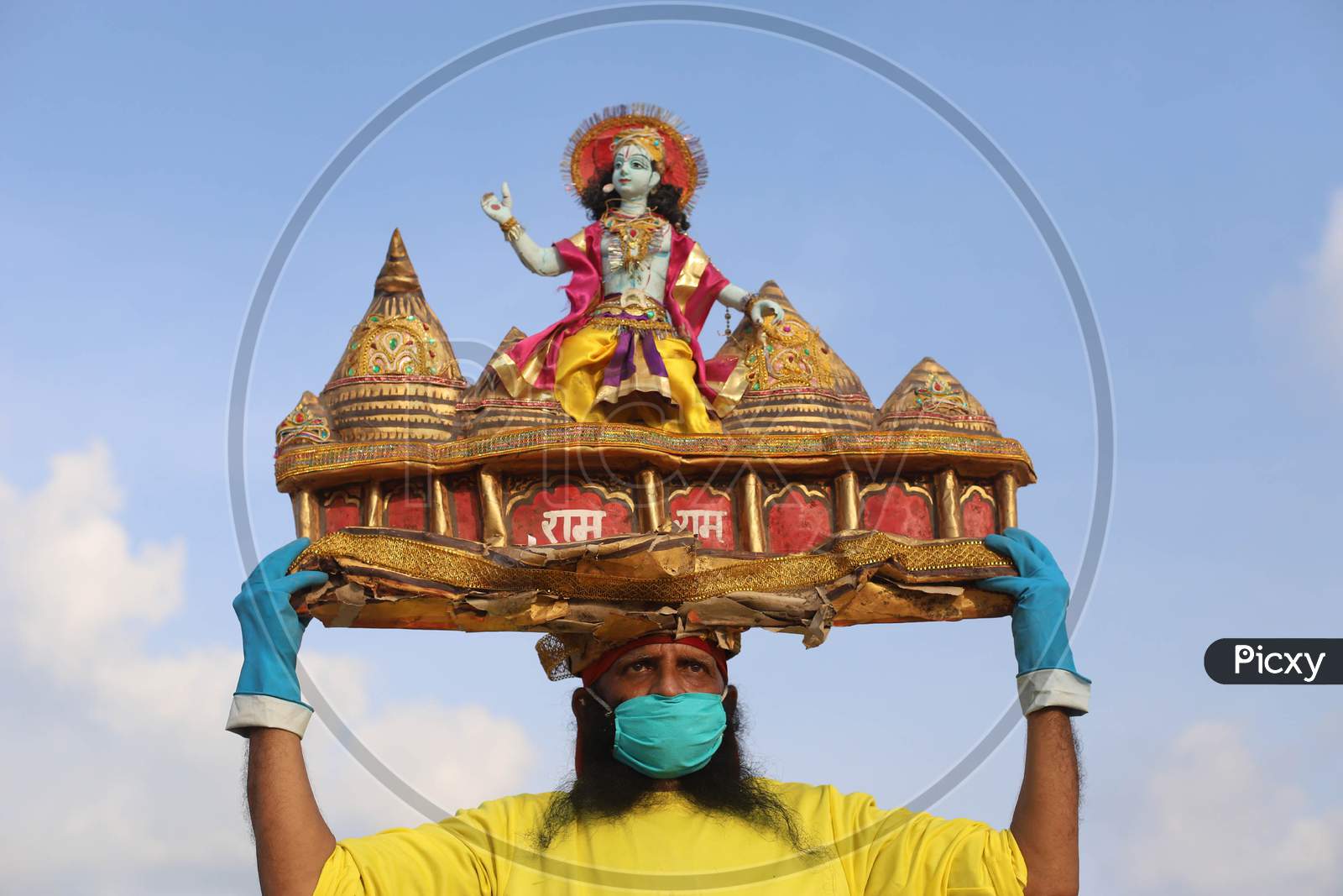 A man holds sculpture of Ram Temple, ahead of the foundation ceremony of Ram temple in Ayodhya, on the banks of River Ganga at Sangam, in Prayagraj, August 4, 2020.