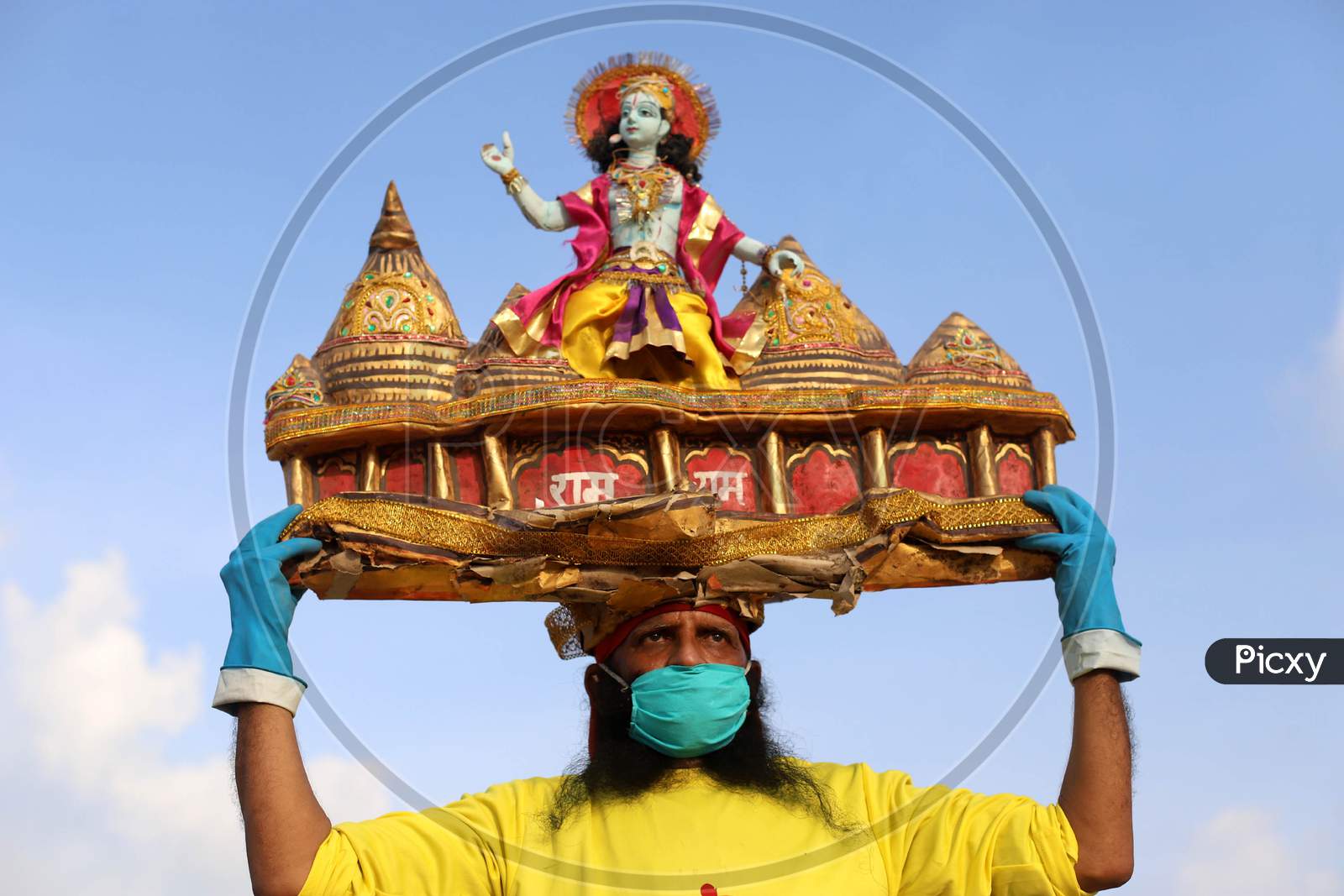 A man holds sculpture of Ram Temple, ahead of the foundation ceremony of Ram temple in Ayodhya, on the banks of River Ganga at Sangam, in Prayagraj, August 4, 2020.