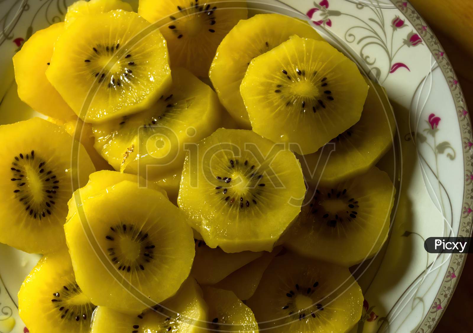 Close Up Shot Of Chopped Fresh Golden Kiwi Fruit On A Plate Kept Under Soft Light