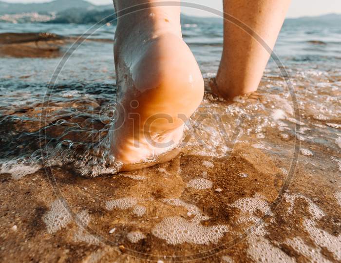 Woman Feet Entering The Sea In The Beach In Spain