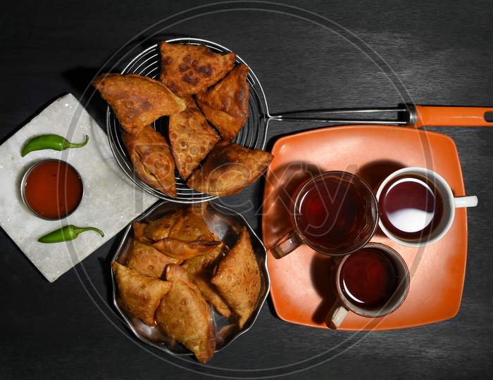 samosa on a plate with sauce and tomatoes. horizontal view from above, rustic style