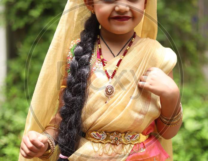 Cute little girl dressed in traditional Indian sari to celebrate Indian festivals like Krishna Janmashtami ,Diwali or Holi.