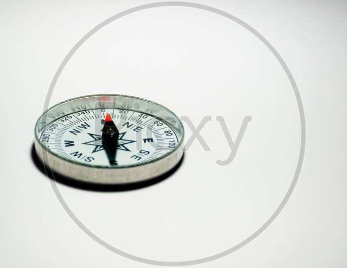 A Compass Pointing North On A Plain White Background With Empty Space