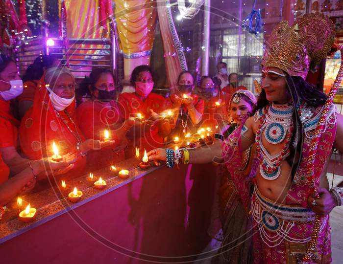 Devotees dressed up as Lord Rama and Goddess Sita light earthen lamps at a temple during the celebrations of the stone laying  ceremony of the Ram Temple by Prime Minister Narendra Modi in Ayodhya, in Chandigarh August 5, 2020