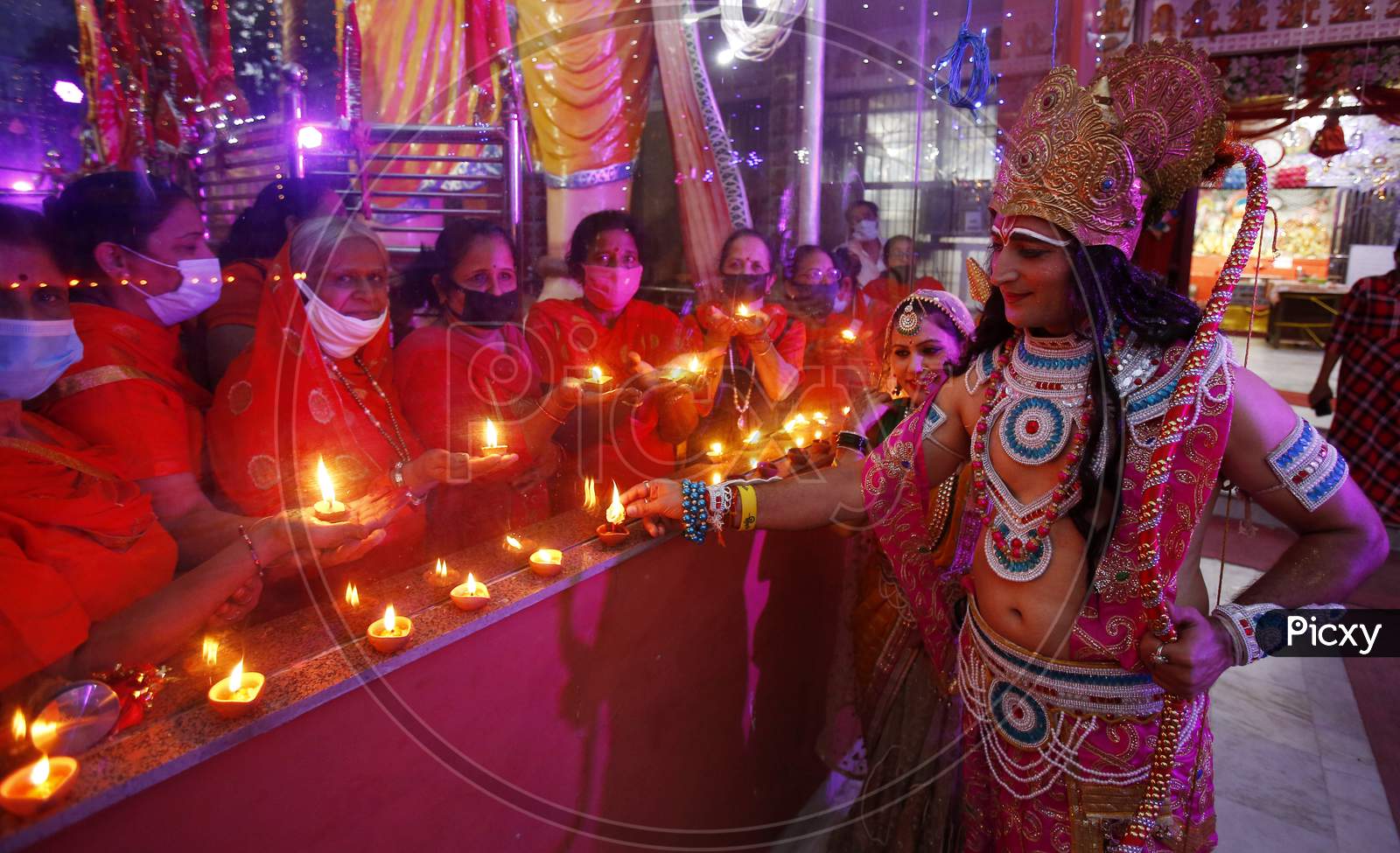 Devotees dressed up as Lord Rama and Goddess Sita light earthen lamps at a temple during the celebrations of the stone laying  ceremony of the Ram Temple by Prime Minister Narendra Modi in Ayodhya, in Chandigarh August 5, 2020