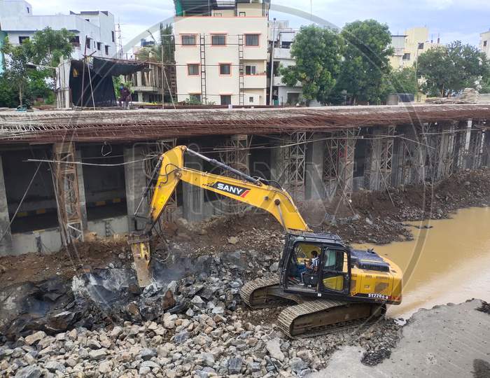 Excavator breaking ground for road development
