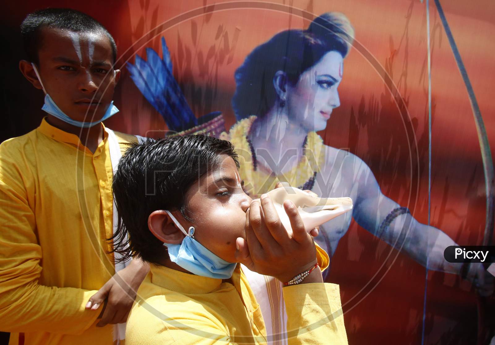 A boy blows a conch shell at BJP local office during the celebrations of the stone laying ceremony of the Ram Temple by Prime Minister Narendra Modi in Ayodhya, in Chandigarh, August 5 , 2020