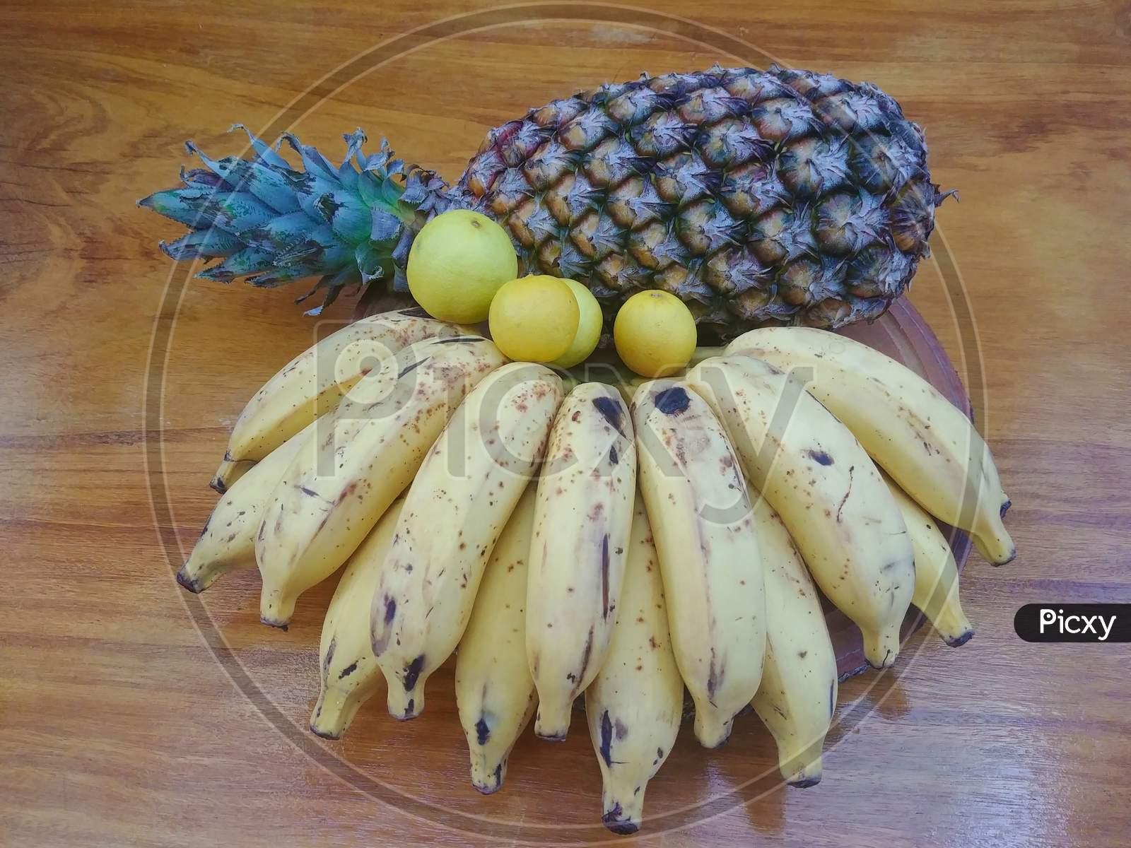 Pineapple, Bananas and Lemons on a wooden table