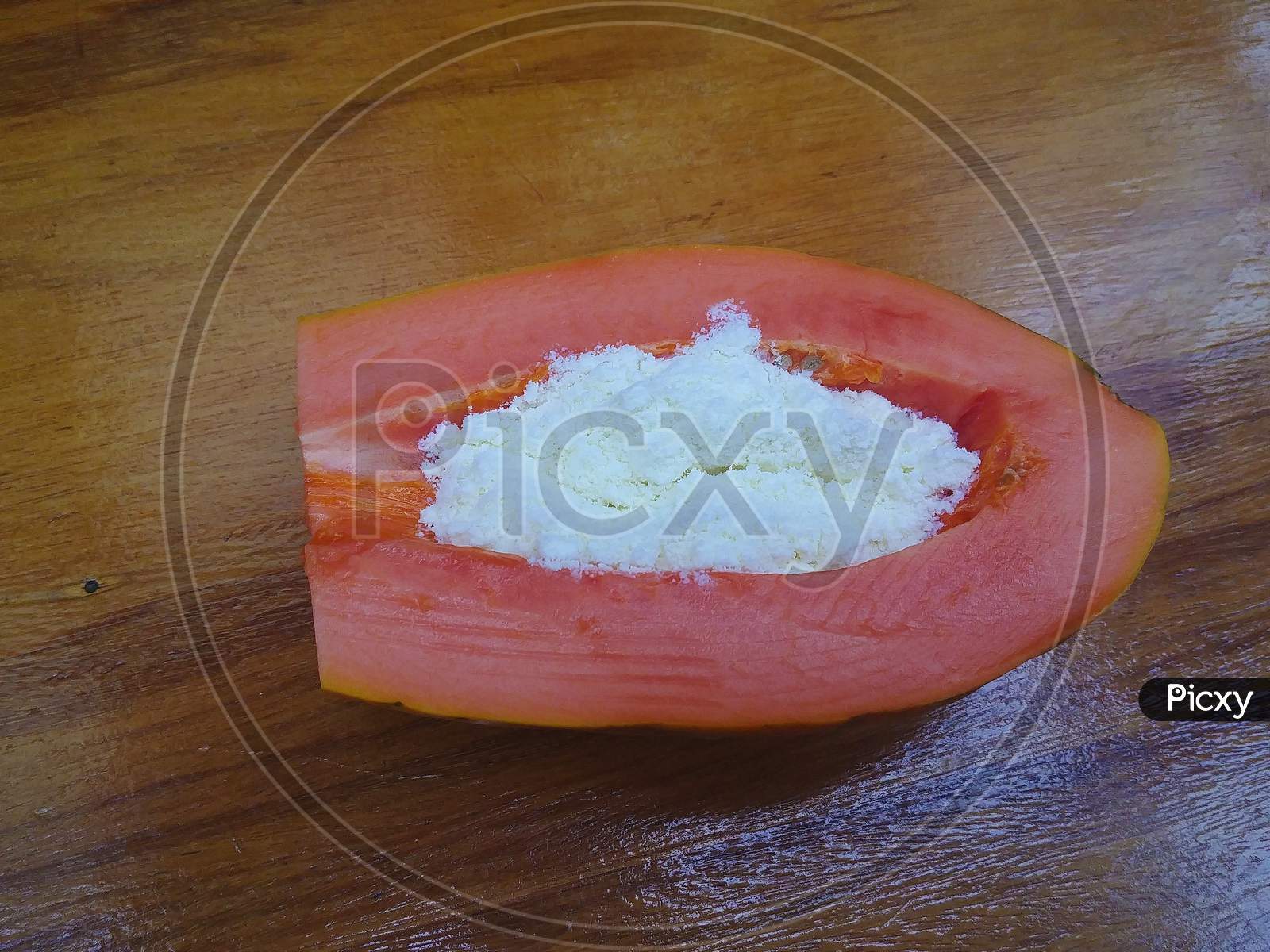 Brazilian papaya with powdered milk on the wooden table