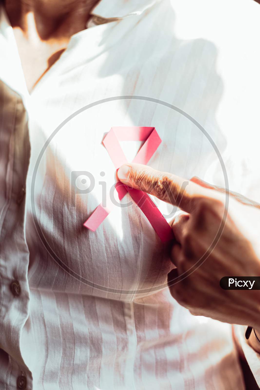 A Old Woman Pointing Pink Ribbon On Chest