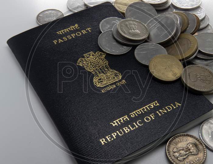 Image Of Indian Passport On White Desk With Rupee Coins.