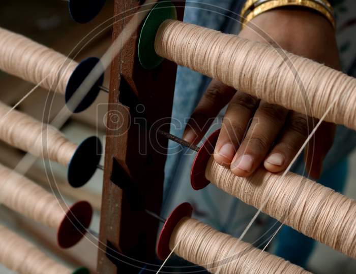 A Handloom Weaver preparing yarns in India.