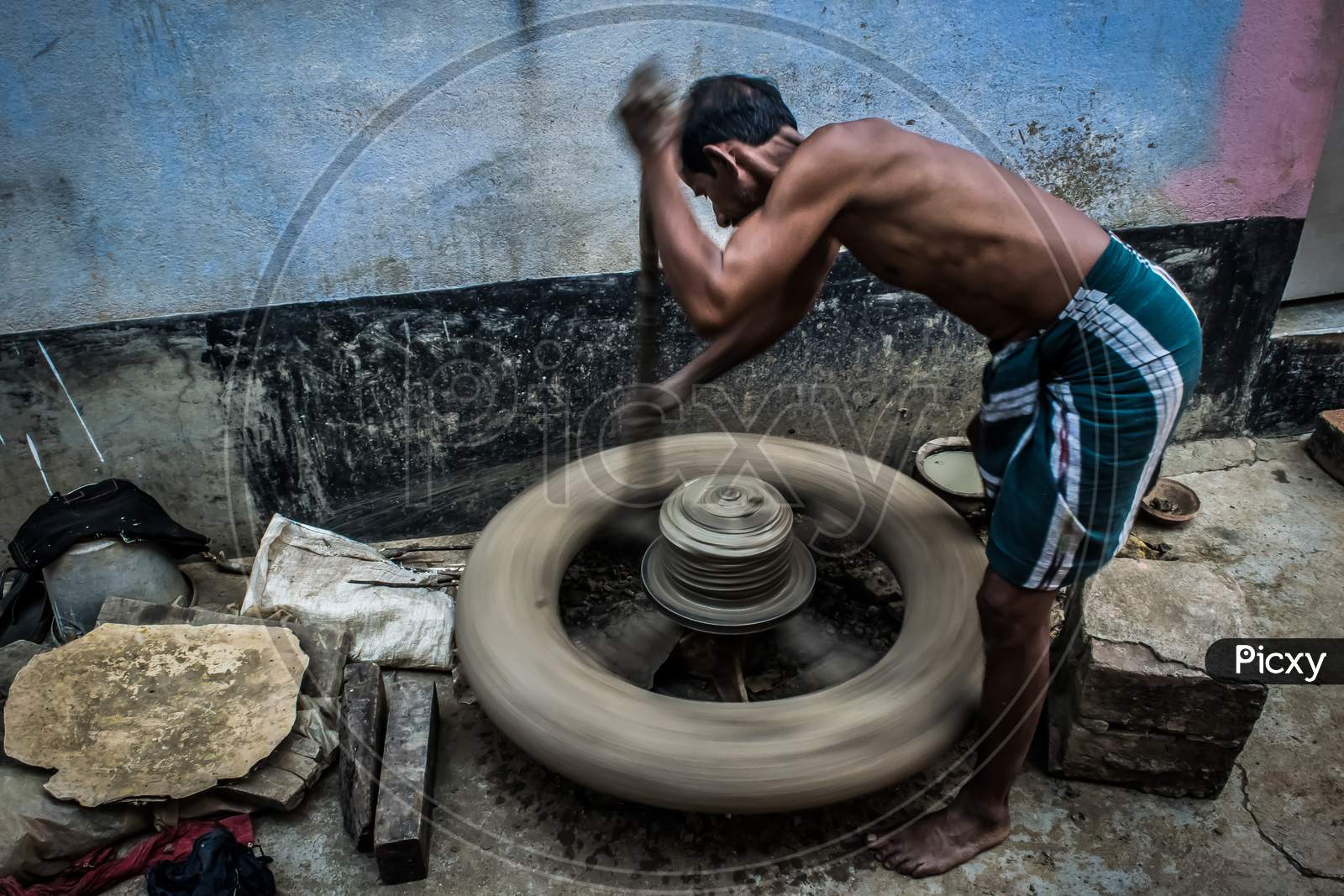 An Artist Is Running A Potter'S Wheel With His Own Hands To Make Traditional Pottery Products