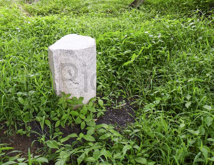White Granite Stone Standing In Green Grass In Garden