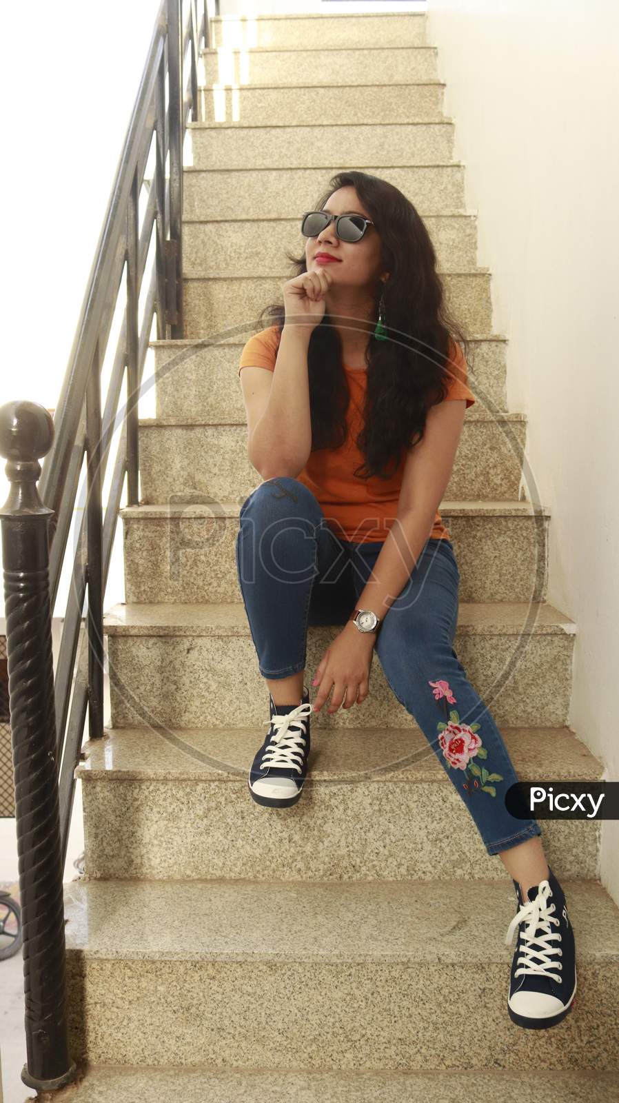 Indian Girl in yellow t shirt and jeans on stair case