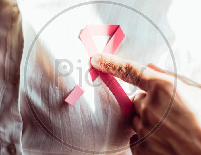A Old Woman Pointing Pink Ribbon On Chest