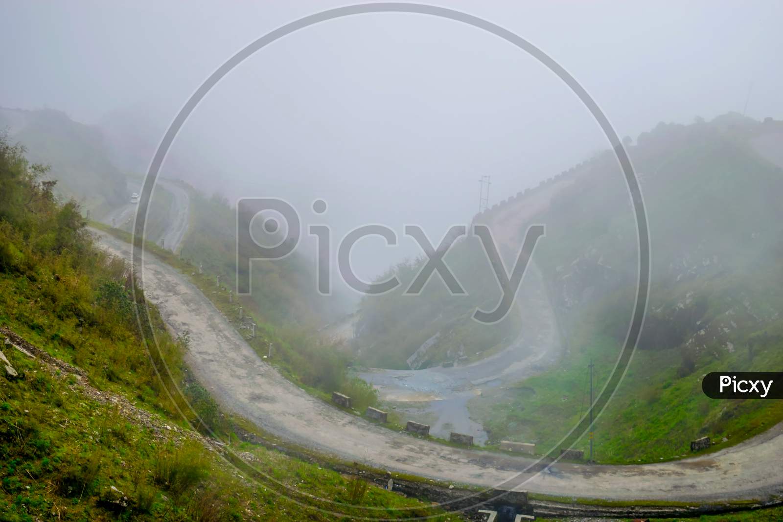 A zigzag road in the Himalayan mountains of Sikkim surrounded by clouds.