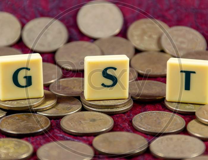 Goods and Services Tax or GST word design with Indian five rupee coin for various type of financial transaction or stock market option