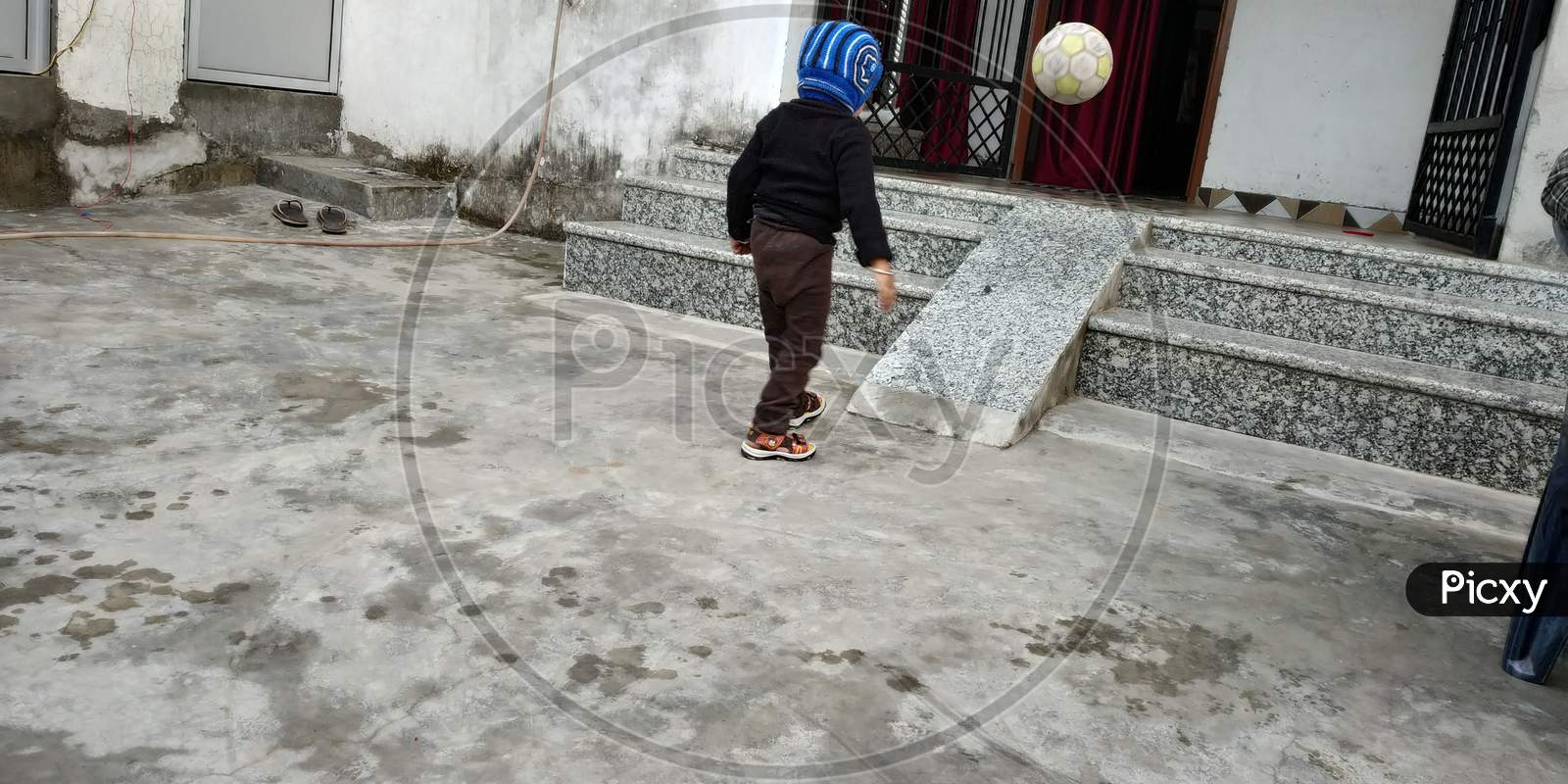 A kid playing with his football