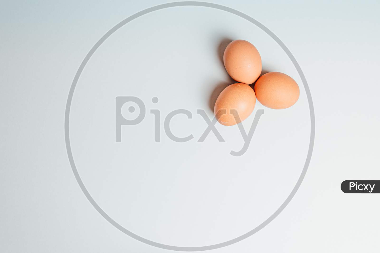White Background With Three Eggs In A Corner