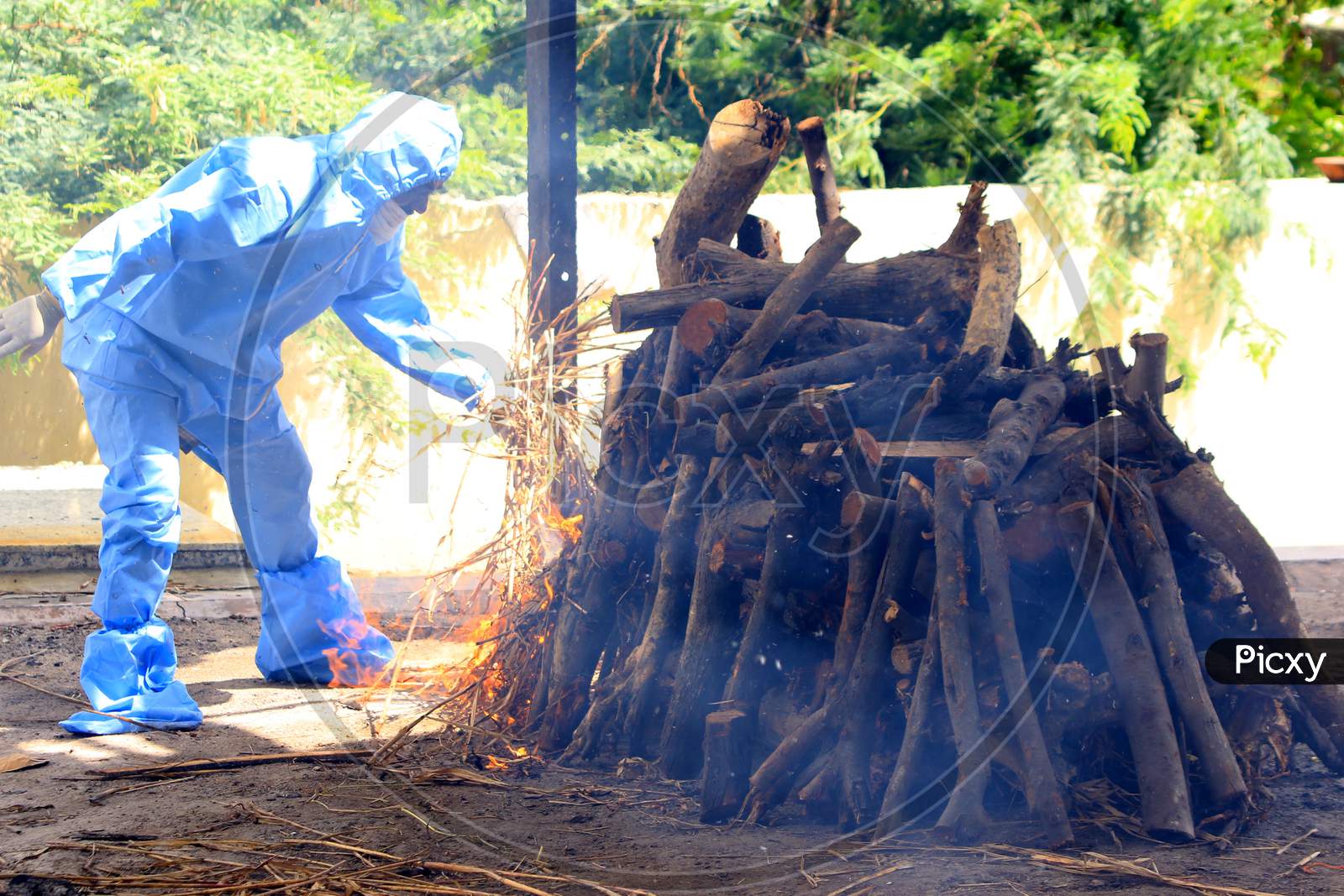 Workers and relatives wearing Personal Protective Equipment (PPE) prepare the cremation for a person who died from the COVID-19 coronavirus, In Ajmer On August 6 2020.