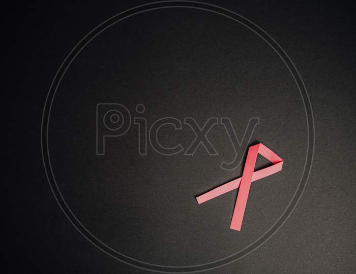 Pink Ribbon Over A Black Background
