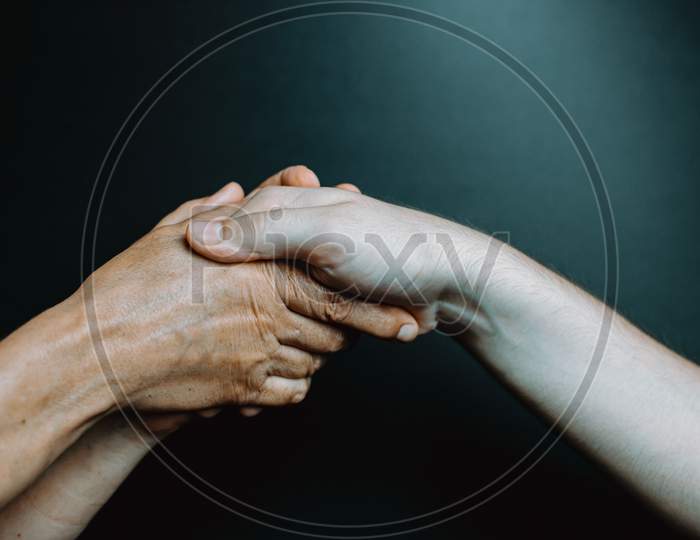 Two Old Hands Caressing Young Hands
