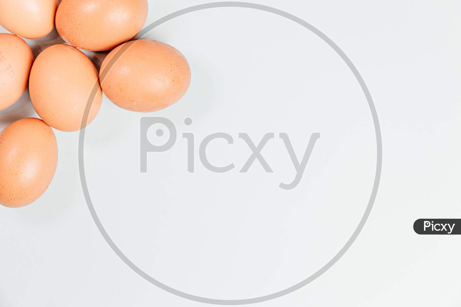 White Background With Eggs Poking Out From One Corner