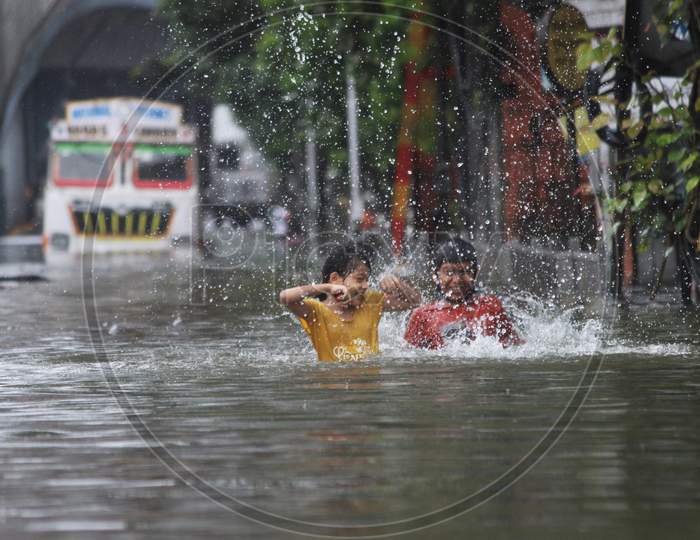 Kids play on a waterlogged road during rains, in Mumbai, India on August 4, 2020.Kids play on a waterlogged road during rains, in Mumbai, India on August 4, 2020.