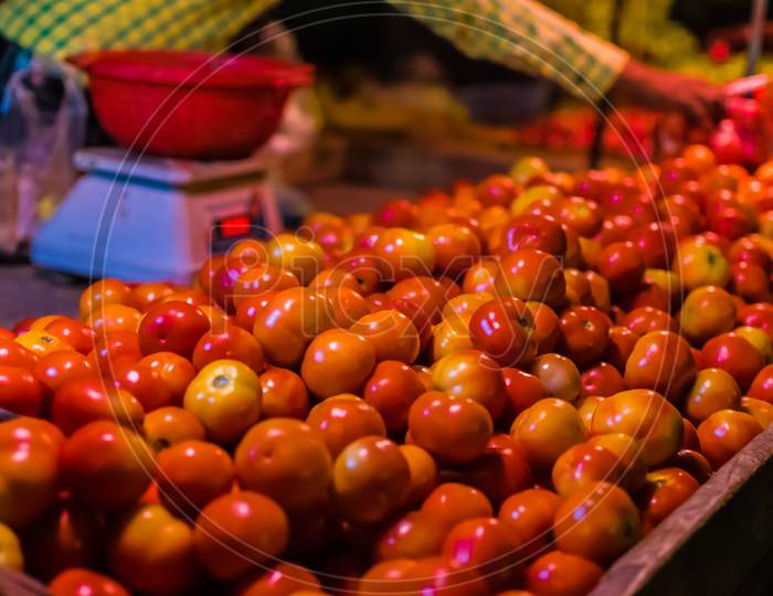 A Vendor Sells Red Fresh Tomatoes In A Cart During The Festival