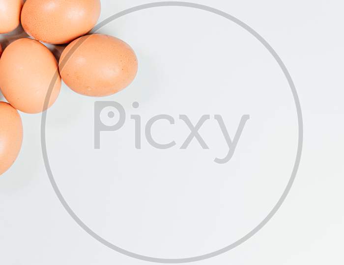 White Background With Eggs Poking Out From One Corner