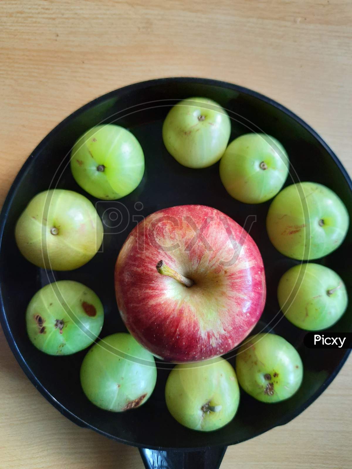 Apple circled by gooseberries