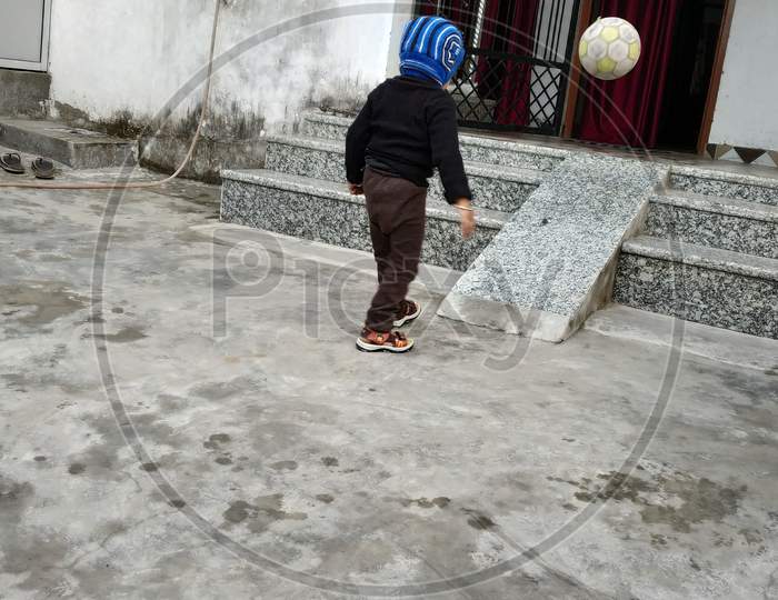 A kid playing with his football
