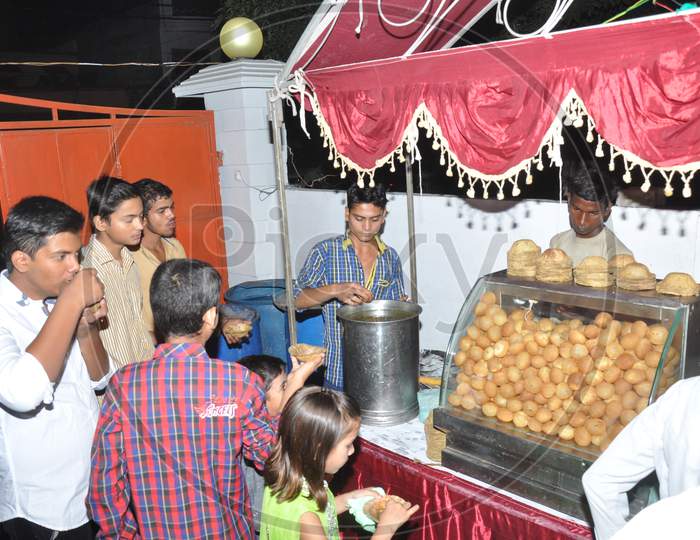 A group of people eating Paani Puri - An indian street food