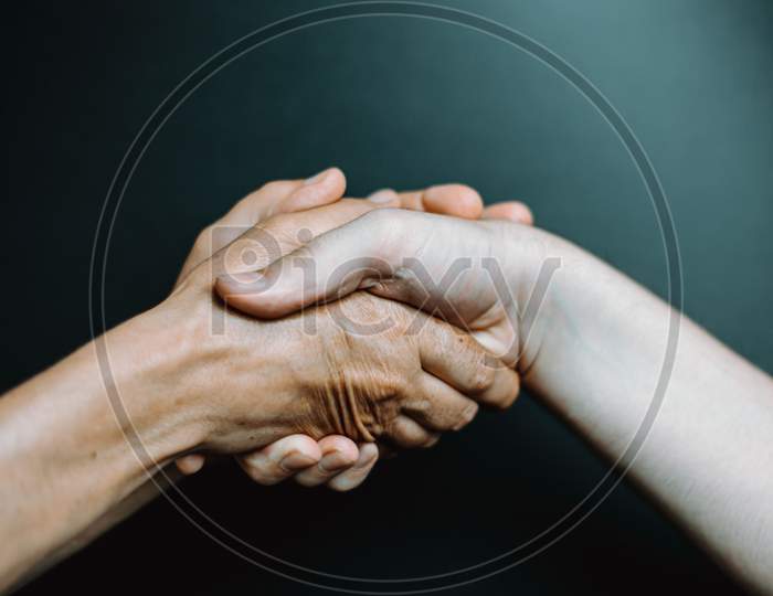 Two Old Hands Caressing Young Hands