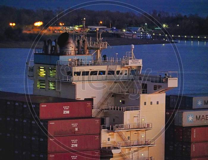 Stacked Containers On Cargo Ship On Blue River Leaving Docks