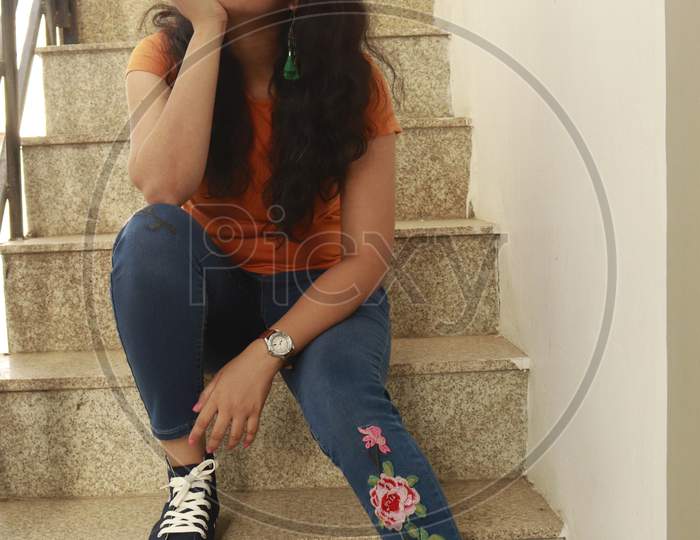 Indian Girl in yellow t shirt and jeans on stair case