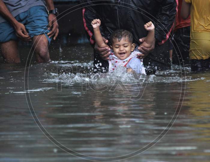 A kid plays on a waterlogged road during rains, in Mumbai, India on August 4, 2020.