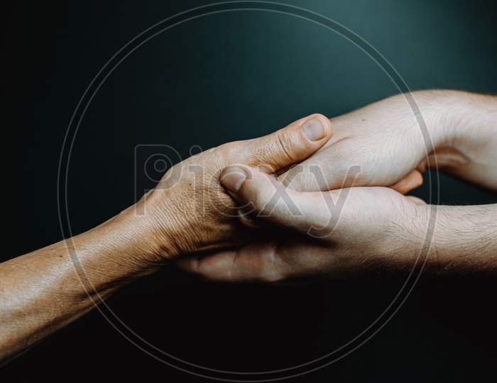 Two Young Hands Caressing Hands Of An Old Woman