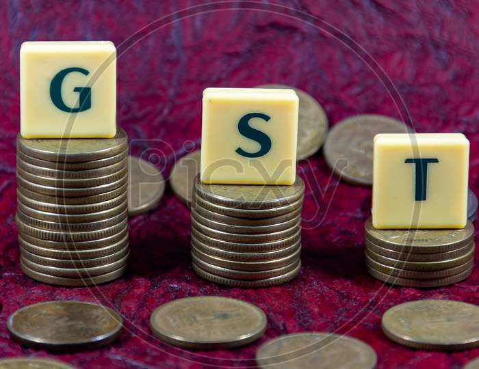 Goods and Services Tax or GST word design with Indian five rupee coin for various type of financial transaction or stock market option