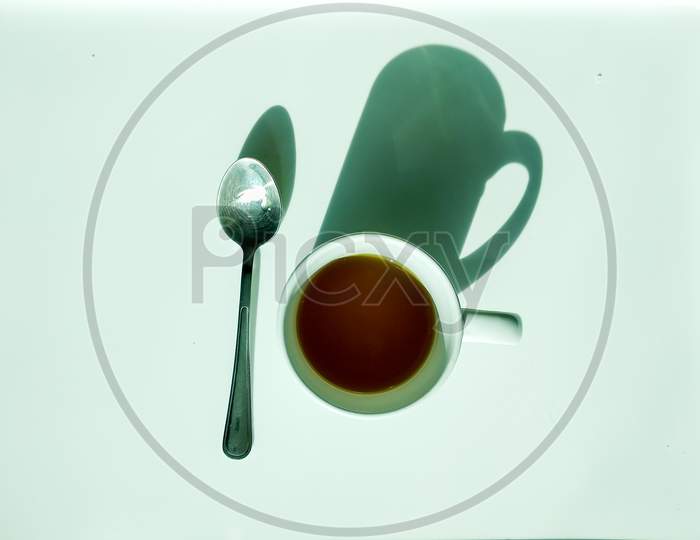 Green Tea In A White Cup And A Metal Spoon, On A White Background, From Above