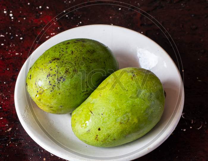 Ripe Himsagar Mango In A Plate Isolated On Reddish Background In Vertical Orientation
