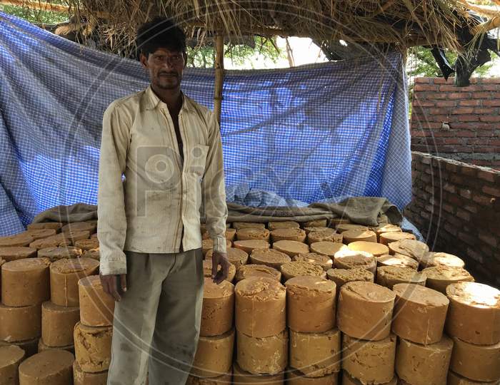 A Man Showing Jaggery Stock Made By Sugarcane Juice