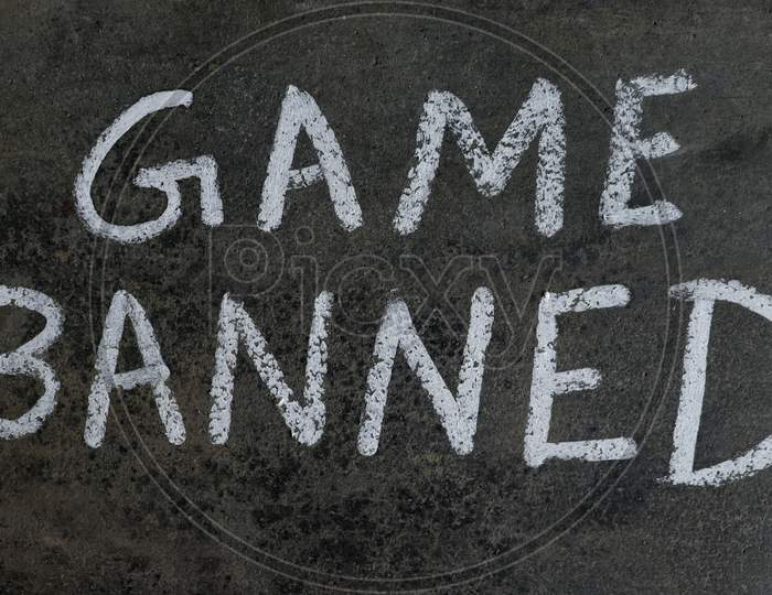 Game Banned Phrase Written On Blackboard With White Chalk